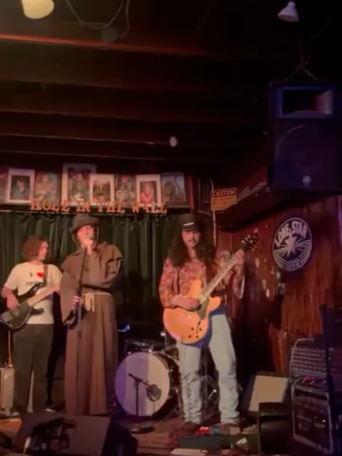 SHWING on stage, guitarist mid-song under the lights